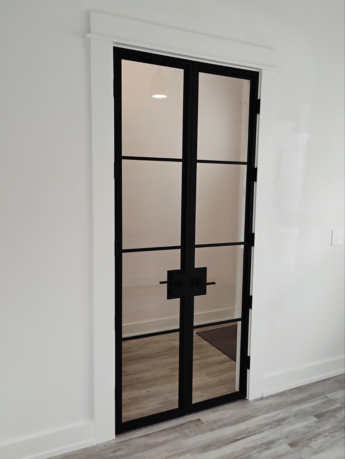 Black-frame interior French doors, custom-built for the space, by AVP Construction JAX in Jacksonville & St. Johns County, FL