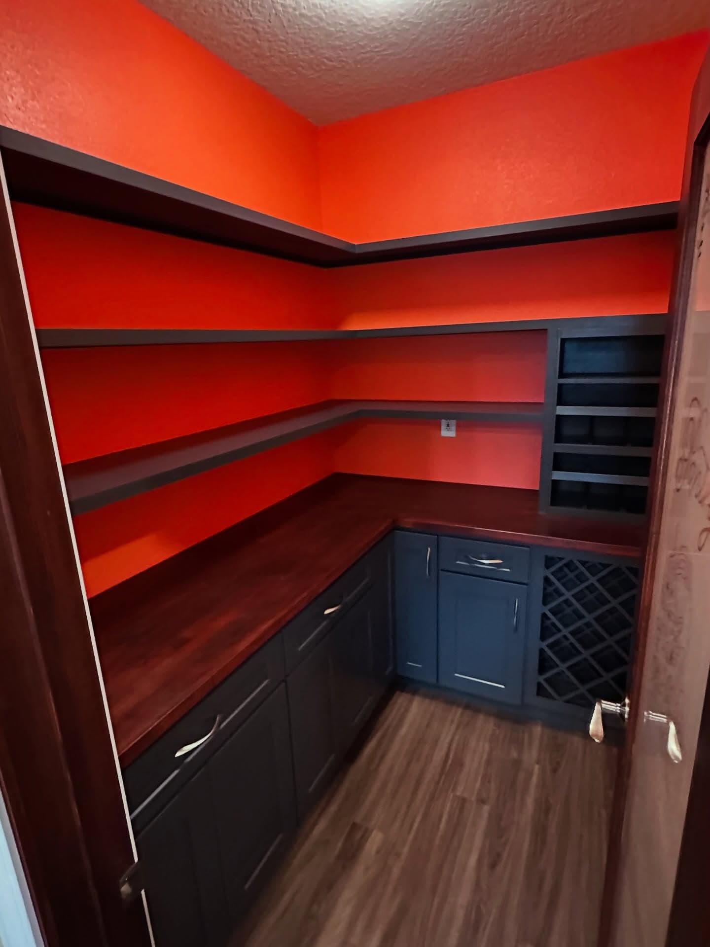 Custom walk-in pantry cabinets with brushed pulls and wine storage by AVP Construction JAX