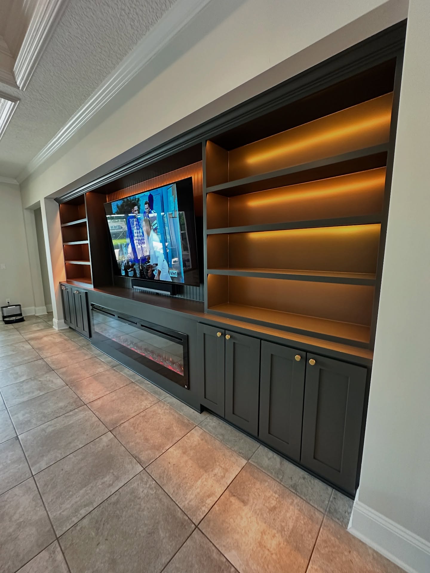 Built-in TV cabinet flanked by display shelving, custom-built for the space, by AVP Construction JAX in Jacksonville & St. Johns County, FL