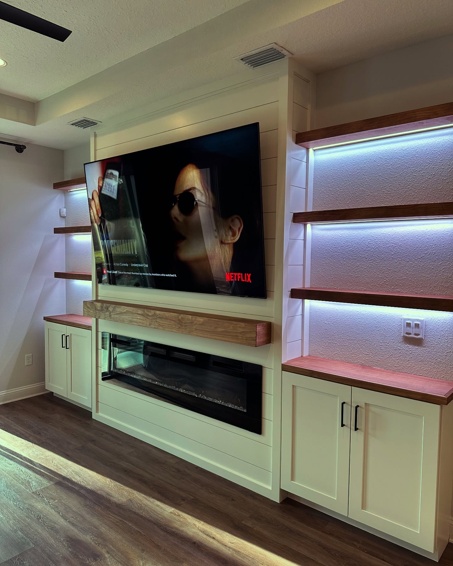 Wall-mounted TV with under-cabinet storage by AVP Construction JAX — Jacksonville & St. John's County, FL