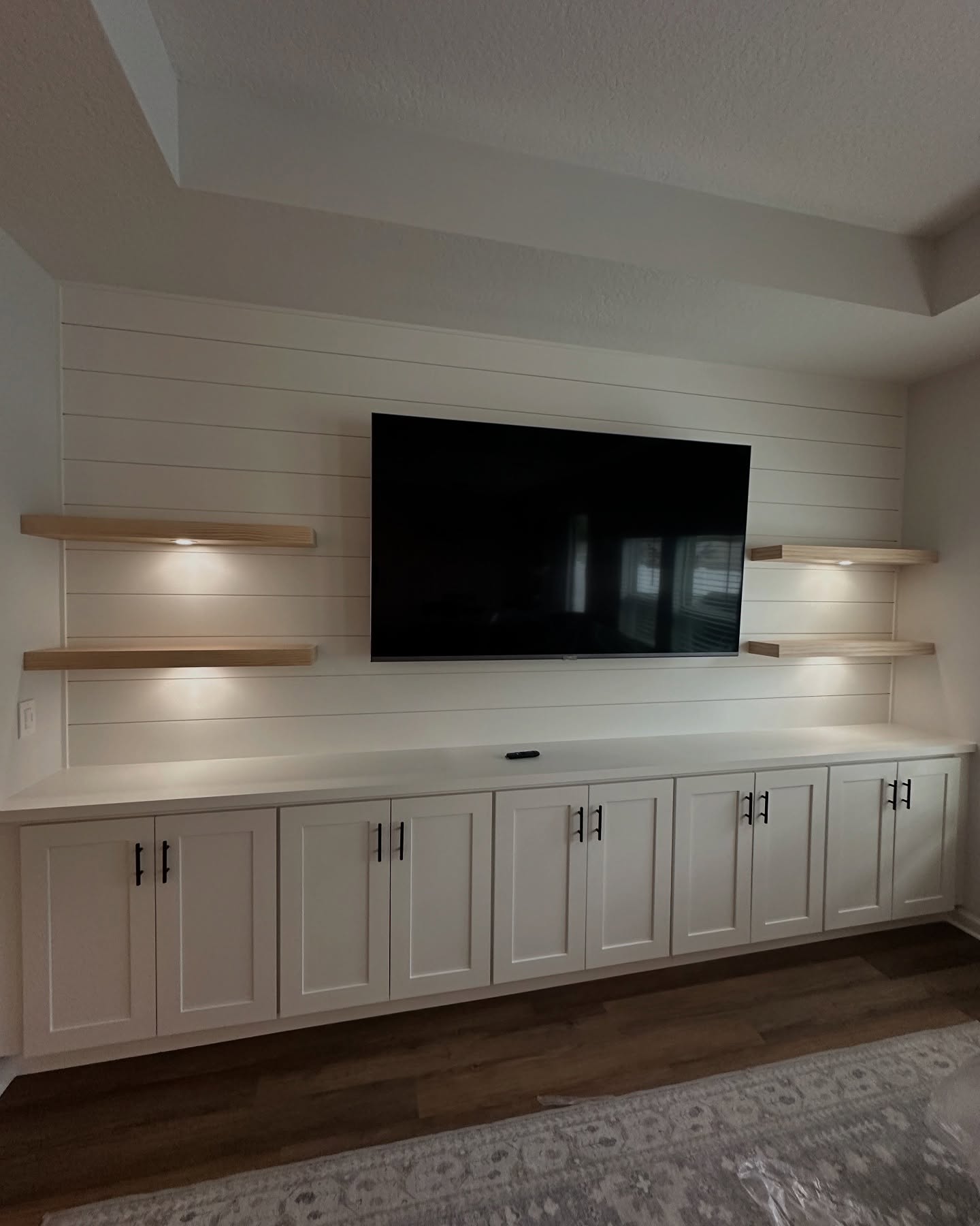 Modern entertainment center with electric fireplace by AVP Construction JAX — Jacksonville & St. John's County, FL
