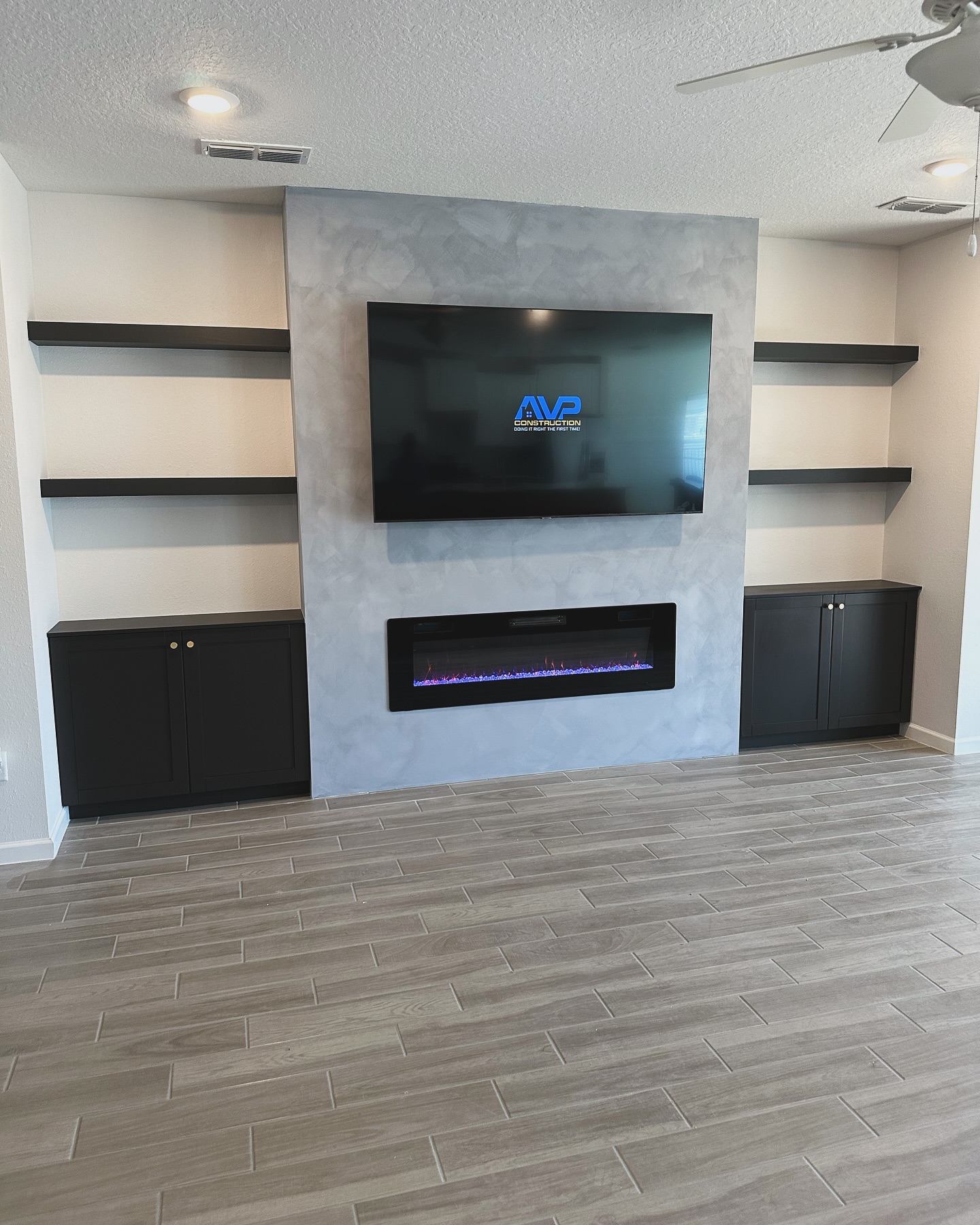 Wall-mounted TV with under-cabinet storage by AVP Construction JAX — Jacksonville & St. John's County, FL