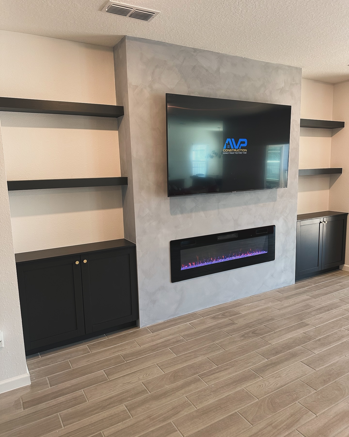 Modern entertainment center with electric fireplace by AVP Construction JAX — Jacksonville & St. John's County, FL