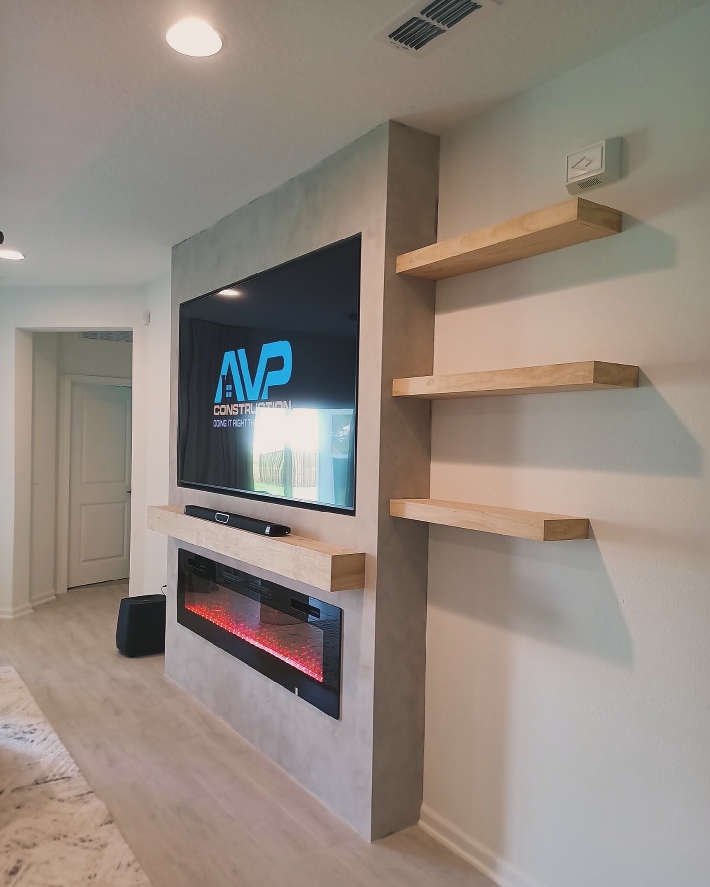 Built-in TV cabinet flanked by display shelving by AVP Construction JAX — Jacksonville & St. John's County, FL