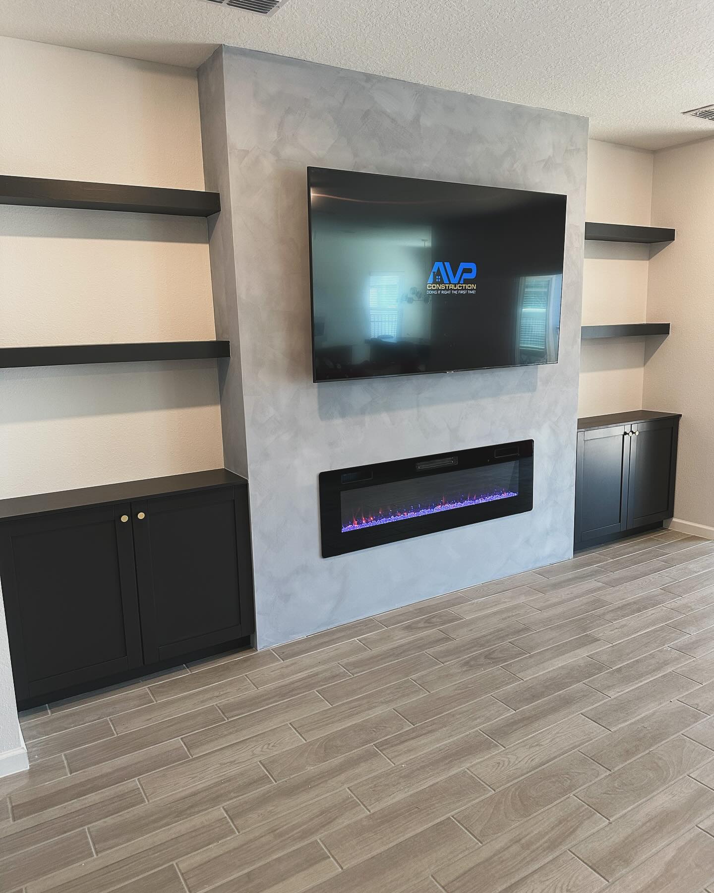 Modern entertainment center with electric fireplace by AVP Construction JAX — Jacksonville & St. John's County, FL