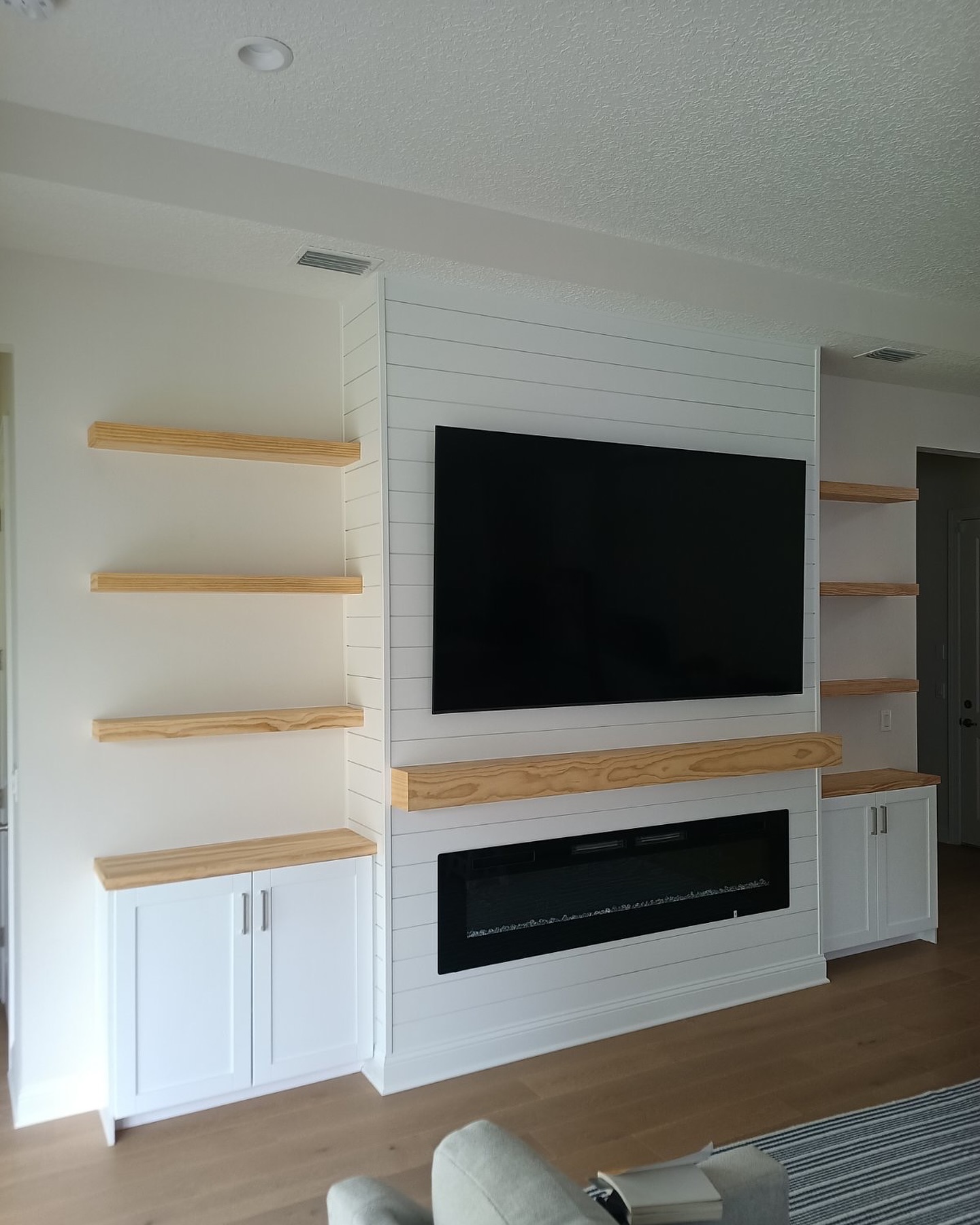 Wall-mounted TV with under-cabinet storage by AVP Construction JAX — Jacksonville & St. John's County, FL
